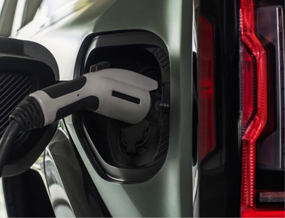Close up of charging port with charger plugged in on a GMC Hummer EV SUV - Zimbrick Buick/GMC West in Madison WI
